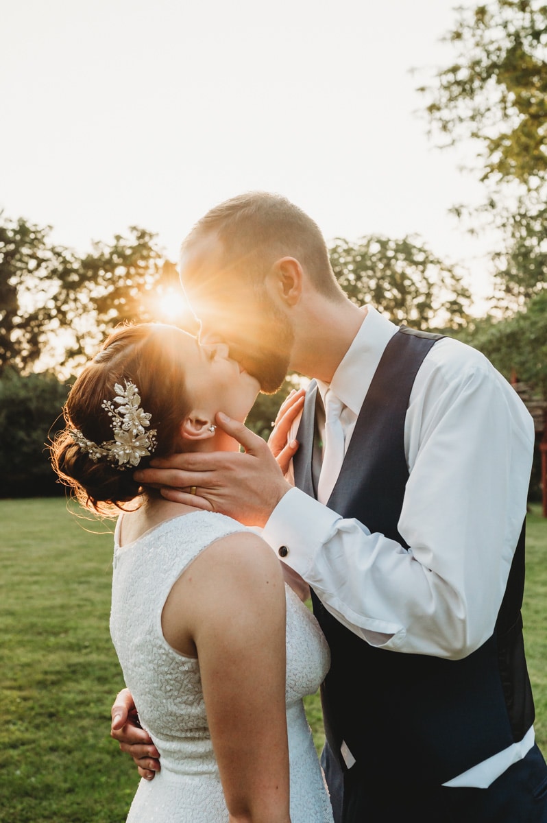 Sunset kiss between bride and groom
