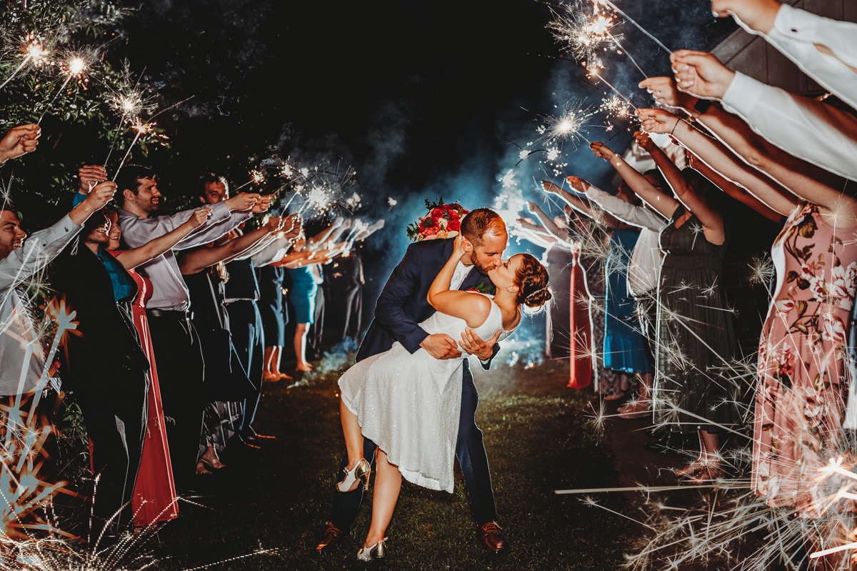 Sparkler exit at backyard wedding - groom dips bride